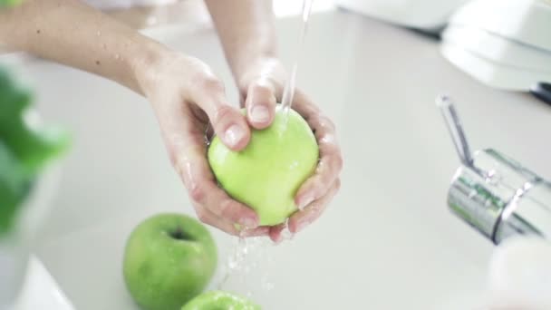 Kvinna som tvättar grönt äpple under kranvatten — Stockvideo