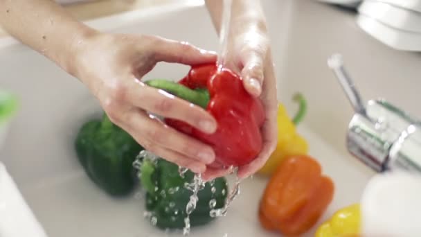 Femme lavage poivron rouge sous l'eau du robinet au ralenti — Video