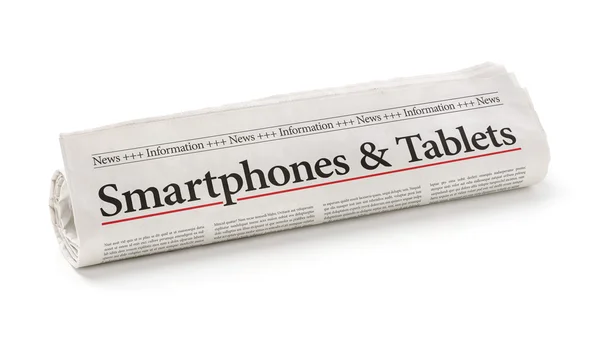 Rolled newspaper with the headline Smartphones and Tablets — Stock Photo, Image
