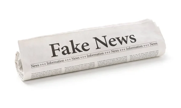 Periódico enrollado con el titular Fake News — Foto de Stock