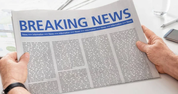 Man reading newspaper with the headline Breaking News — Stock Photo, Image