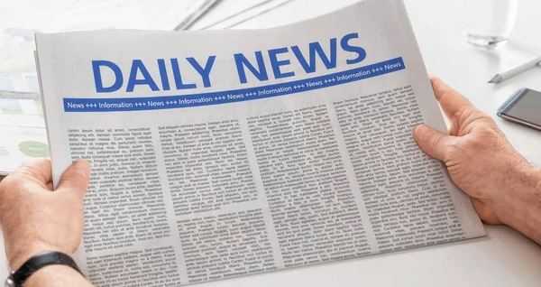 Man reading newspaper with the headline Daily News — Stock Photo, Image