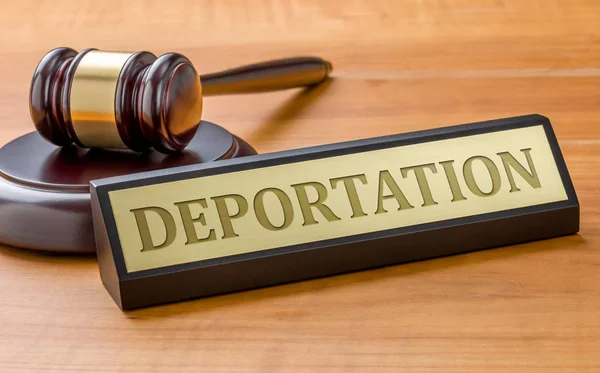 Einen Hammer und ein Namensschild mit der eingravierten Deportation — Stockfoto