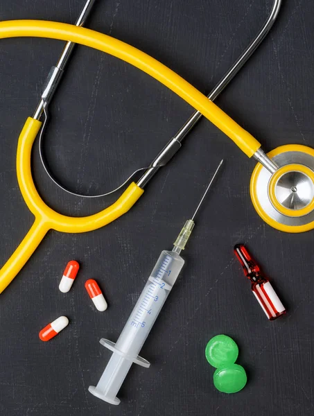 Stetoskop och läkemedel på en svart tavla — Stockfoto