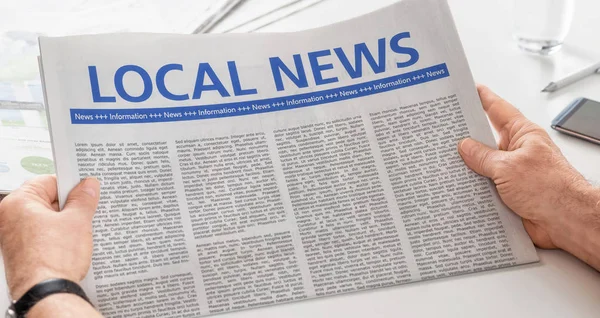 Man reading newspaper with the headline Local News — Stock Photo, Image