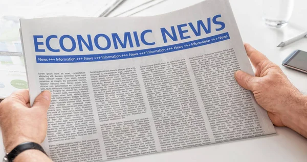 Mann liest Zeitung mit der Schlagzeile Wirtschaftsnachrichten — Stockfoto