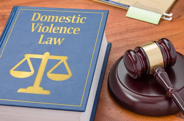 Sebuah buku hukum dengan gavel hukum kekerasan dalam negeri — Stok Foto