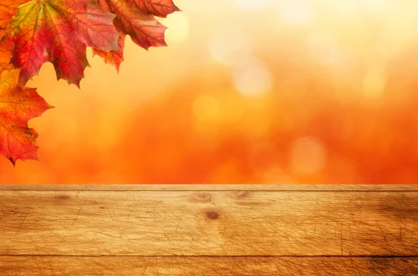 Rustic wooden table with an autumnal background — Stock Photo, Image