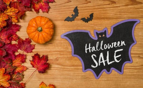 Höstlöven med en pumpa och en blackboard - Halloween försäljning — Stockfoto