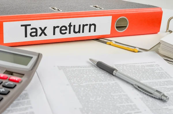 An orange folder with the label Tax return — Stock Photo, Image