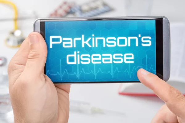 Смартфон с текстом болезни Паркинсона на дисплее — стоковое фото