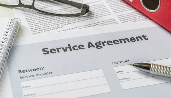 A szolgáltatási megállapodás egy asztal toll — Stock Fotó