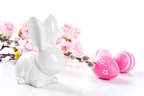Un conejito de Pascua con un huevo rosa sobre un fondo blanco — Foto de Stock