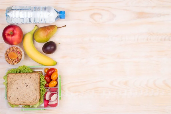 Lancheira com sanduíche, frutas, legumes e água — Fotografia de Stock