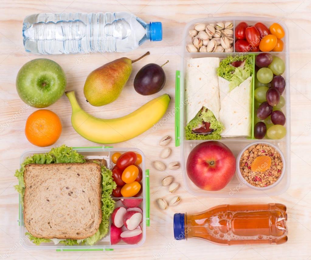Food for lunch, lunchboxes with sandwiches, fruits, vegetables, and drinks