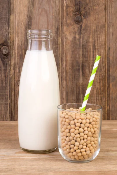 Leche de soja en botella y soja en vaso con paja para beber — Foto de Stock