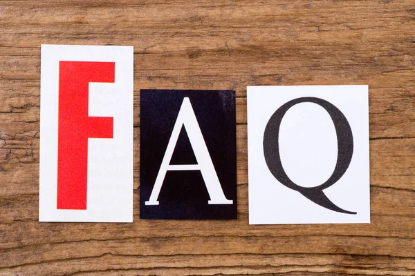 Phrase "FAQ" on wooden background Stock Picture