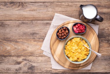 Kavanozda mısır gevrekleri ve bir sürahi süt kırsal ahşap masa üzerinde, fotokopi alanı ile üst manzara