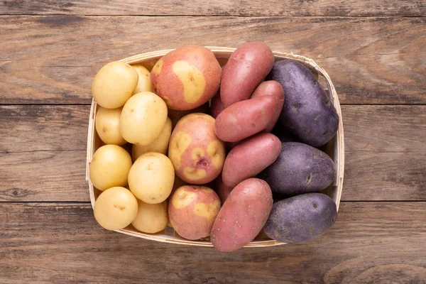 不同类型的土豆放在木制的乡村桌子上的盒子里 — 图库照片