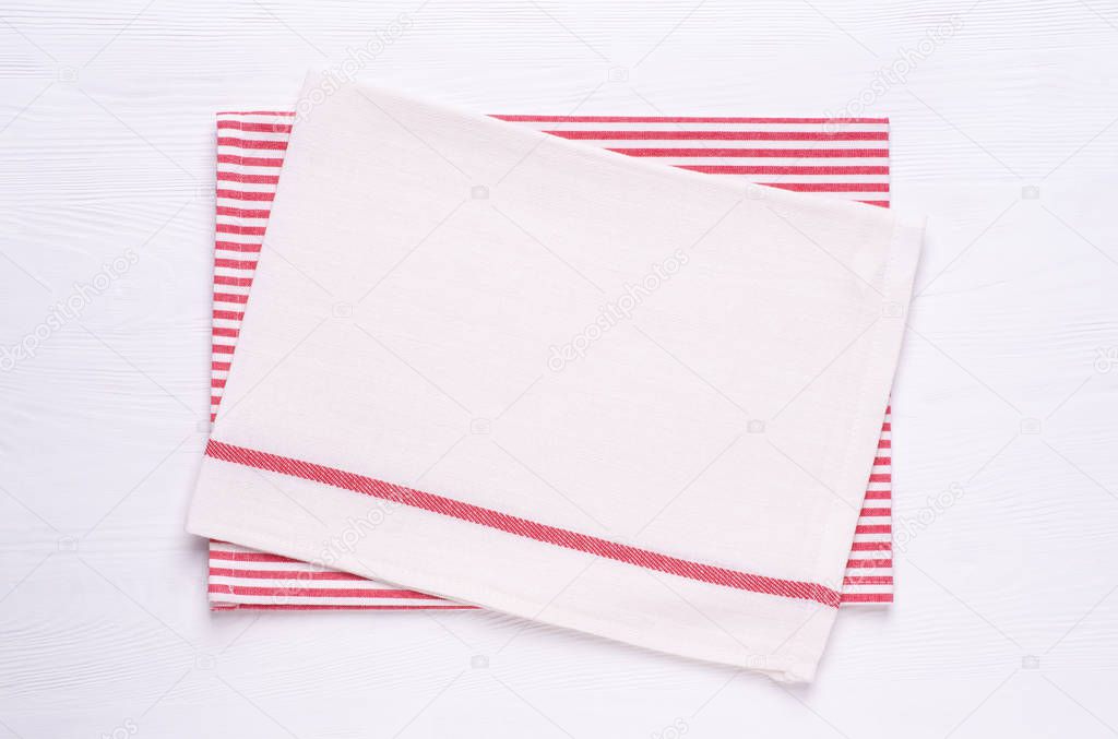 Kitchen towels or napkins on white wooden table top. Mock up for design. Top view