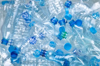 Beyaz arka planda fotokopi alanı olan bir sürü plastik şişe.