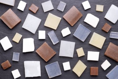 Siyah taş arka planda beş farklı gliserin sabun bazlı çubuklar.