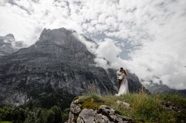 beautiful young wedding couple hugging in majestic mountains, Alps clipart