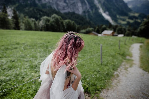 beautiful young bride walking in mountain valley in Alps