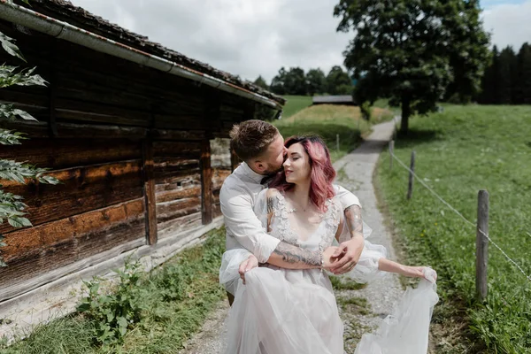 Knappe Bruidegom Zoenen Knuffelen Bruid Trouwjurk Alpen — Gratis stockfoto