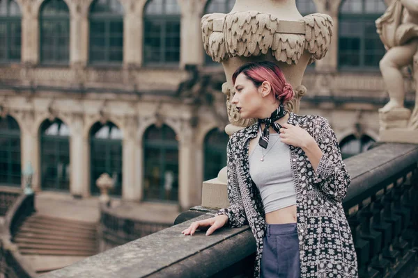 Красивая задумчивая молодая женщина смотрит в сторону, стоя возле дворца барокко в Дрездене, Германия — стоковое фото