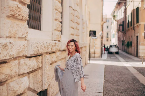 Chica elegante feliz en vestido glamoroso caminando en Verona - foto de stock