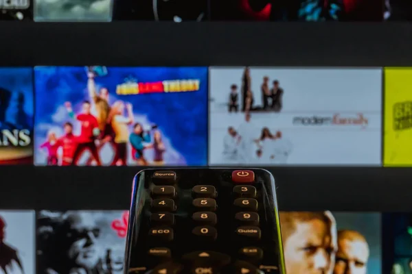 Video on demand screen with remote control in hand