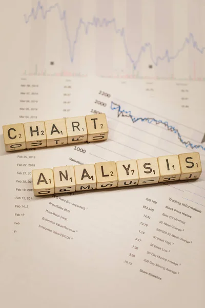Closeup of word Chart Analysis on wooden blocks on financial report, background concept