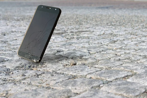 Smartphone cayendo y estrellándose en el pavimento — Foto de Stock