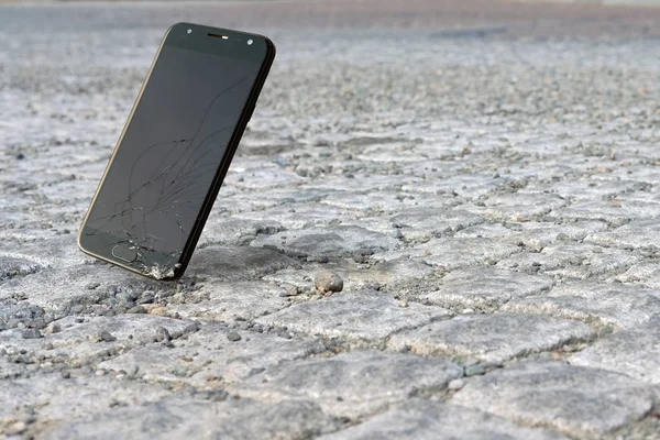 Akıllı telefon yere düşüyor ve yere çakılıyor.