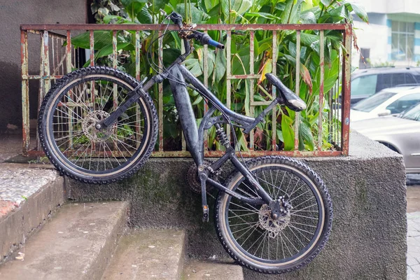 Bicicleta negra apoyada contra valla metálica —  Fotos de Stock