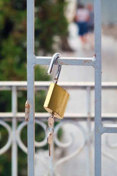 Öppet rostigt lås med nycklar hängande på grinden — Stockfoto