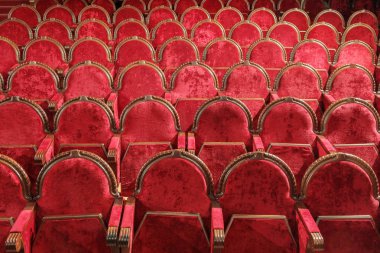 Boş kırmızı ahşap ve kadife sandalyeler.