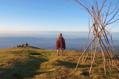 Tepenin üstünde yorganı olan bir turist. 