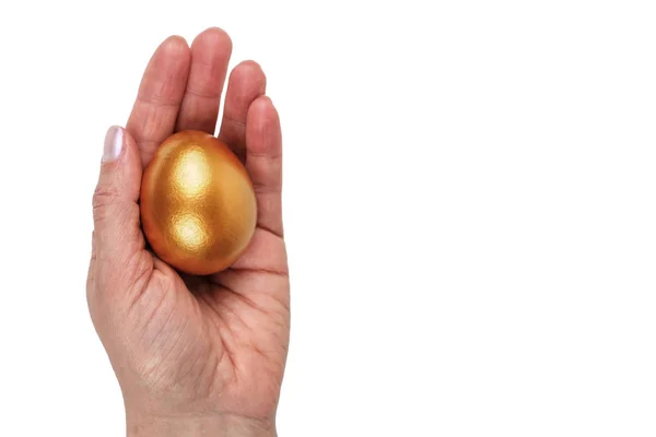 Ruce držící zlaté velikonoční vejce — Stock fotografie