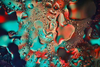 Su soyut bir arkaplanda yeşil ve kırmızı renkte damlar.