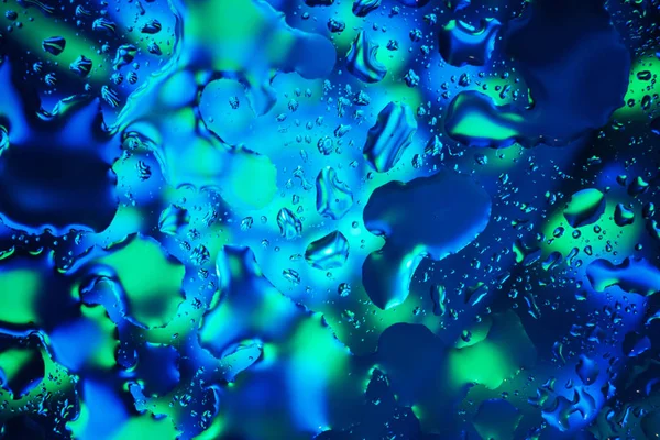 Вода падає на барвистий абстрактний фон — стокове фото