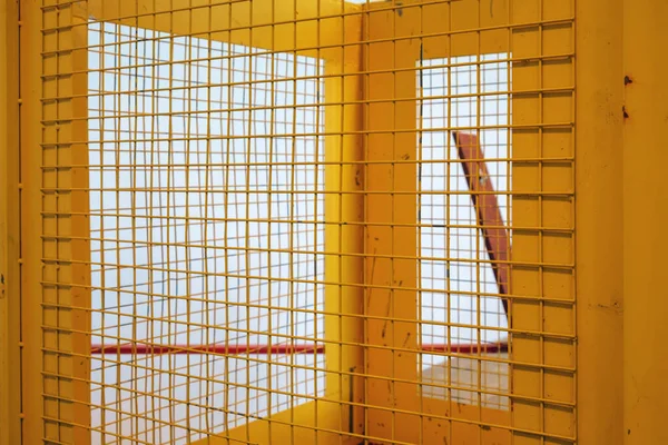Portão de rede de metal amarelo com fundo branco — Fotografia de Stock