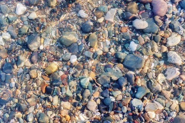 Rochers colorés et cailloux sous l'eau claire — Photo