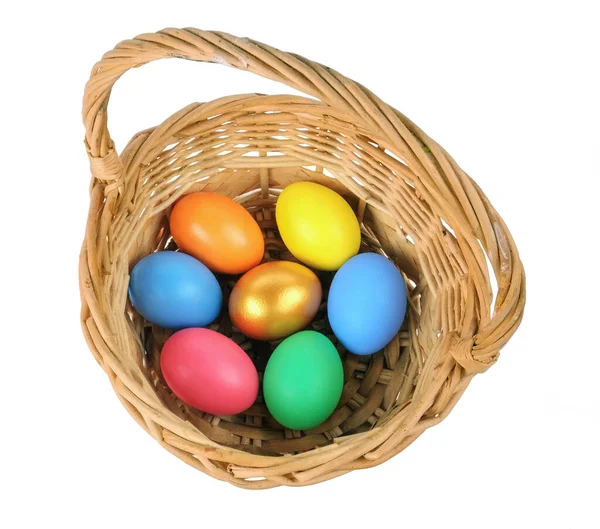 Цветные пасхальные яйца в корзине на белом фоне — стоковое фото