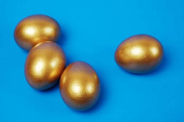 Zlatá Velikonoční Vajíčka Modrém Povrchu — Stock fotografie