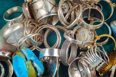 Koyu yeşil kadife arka planda farklı yüzük ve mücevher koleksiyonu.