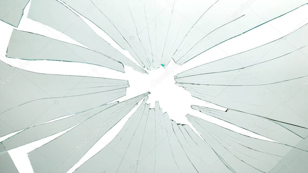 Closeup of broken and cracked glass with hole on a white background