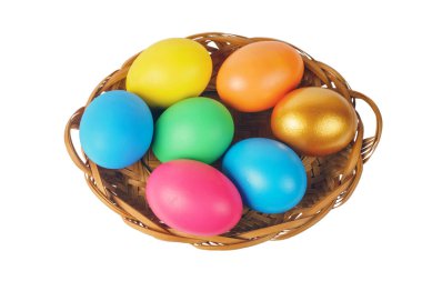 Beyaz arka planda sepette renkli Paskalya yumurtaları var.