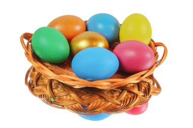 Sepetteki renkli Paskalya yumurtaları beyaz yüzeyi yansıtıyor.
